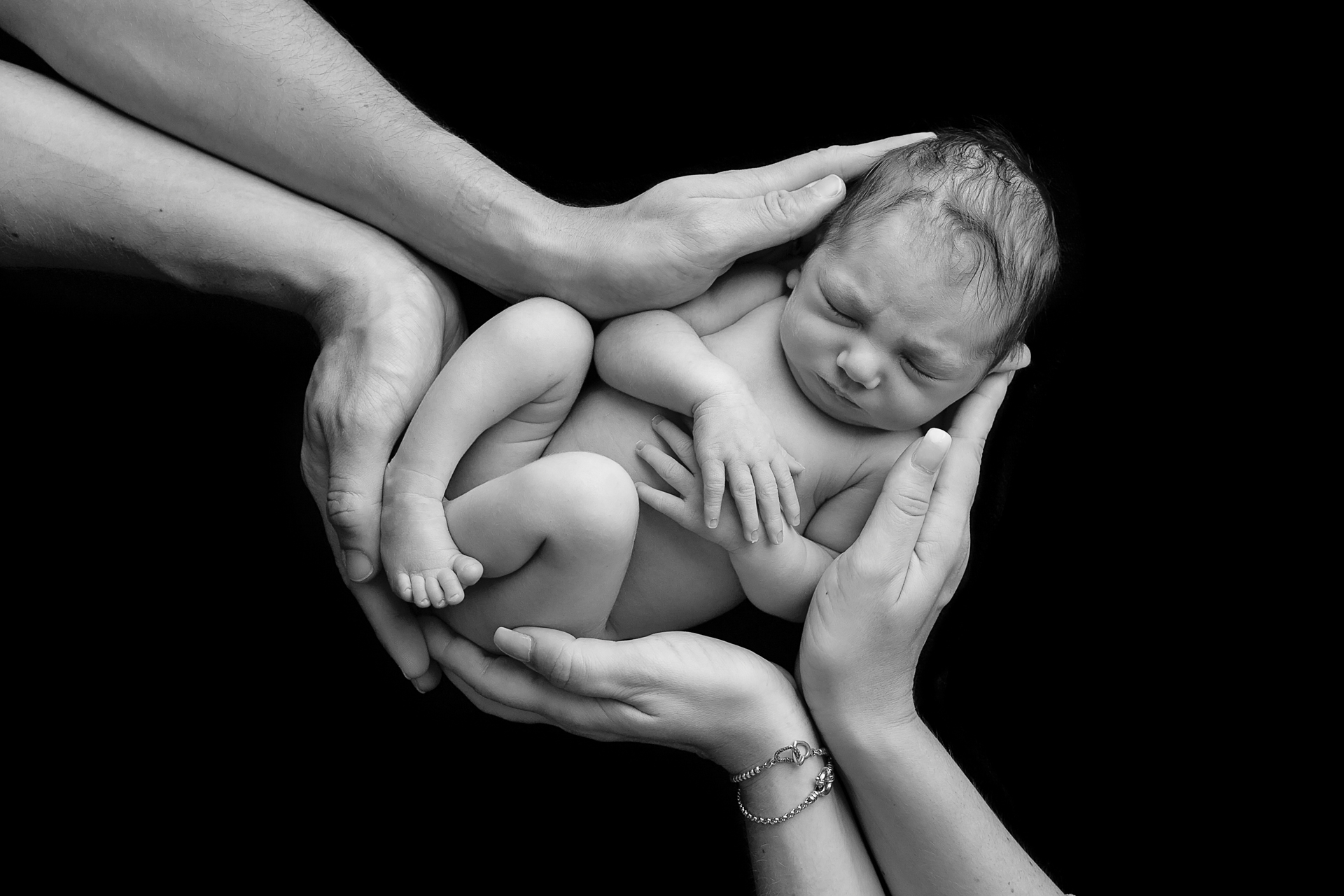 Newborn held gently