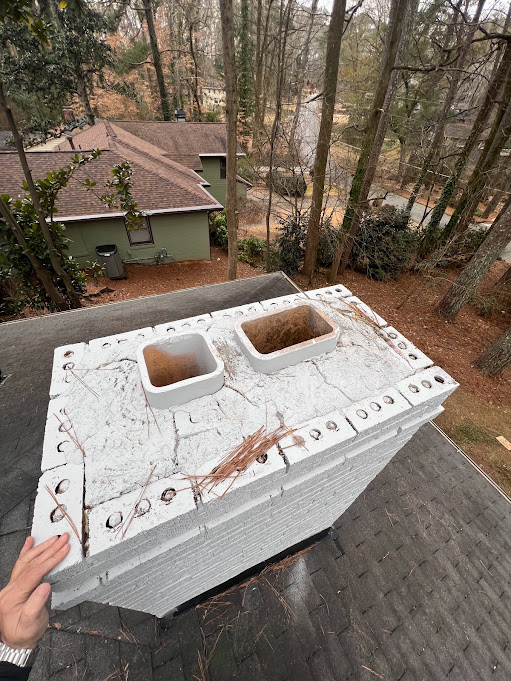 Precast concrete chimney cap with two flue openings being lifted into position