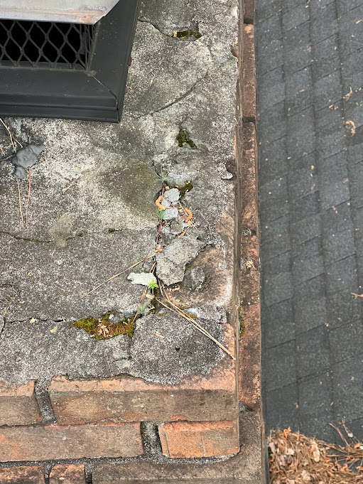 Crumbling mortar crown with loose chunks and debris scattered on the roof below