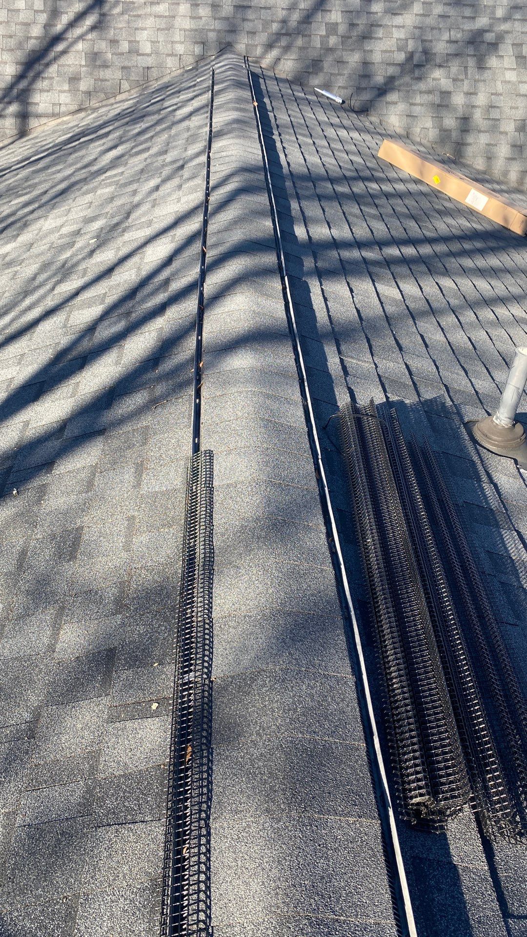 Close-up of a shingle roof ridge line with exclusion strip installed in Marietta