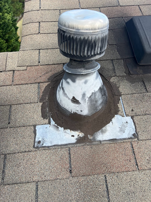 Repaired vent flashing base resealed and tied back into the surrounding shingle courses