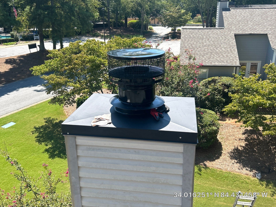 Rusted mesh chimney cap showing corrosion and worn coating