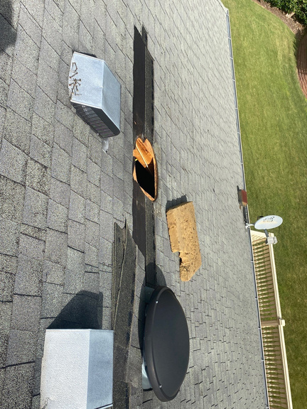 Roof with the old attic fan removed, the opening cut clean, and a new dome fan staged beside it