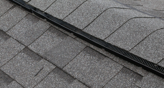 Long ridge vent strip running the length of a shingle roof peak