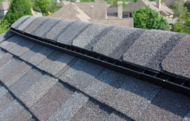 Ridge vent strip running along the peak of a shingle roof