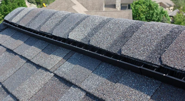 Close-up view of shingles along a roof valley near a dormer