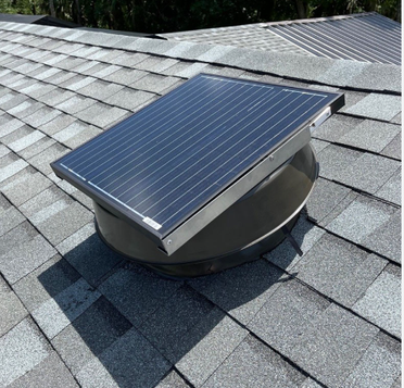 Solar attic fan on a shingle roof in bright sunlight