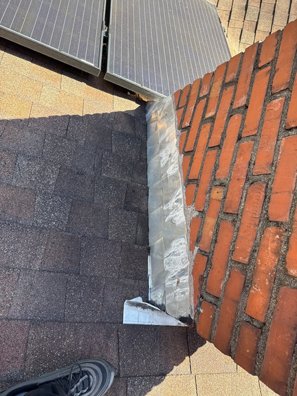 Flashing meeting a brick chimney on a shingle roof