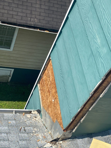 Crew removing damaged siding panels during a repair