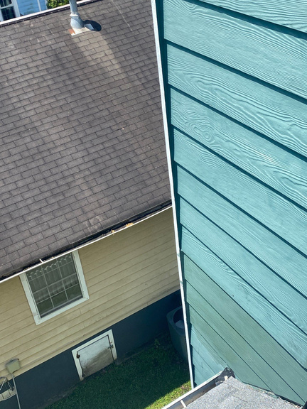 Aerial view of a home with teal fiber cement siding and shingled roof