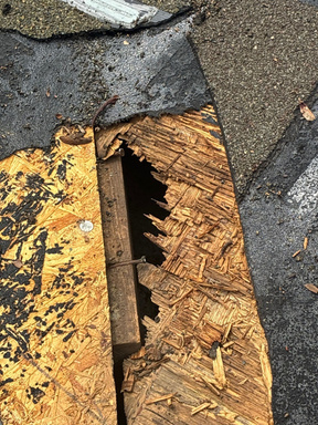 Soft, rotted roof decking exposed at the roof edge