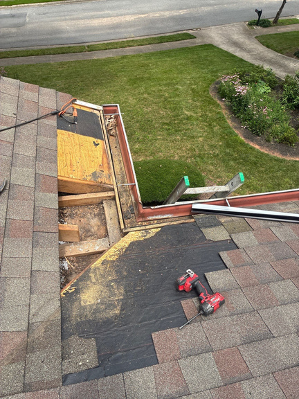 Crew replacing rotted decking with exposed underlayment at roof edge