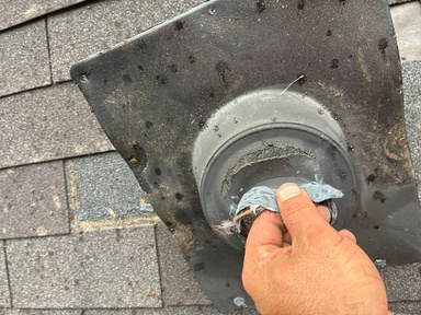 Technician documenting a pipe boot with a photo