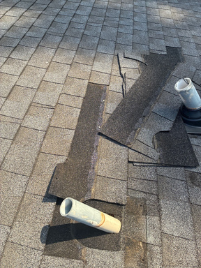 Storm clouds over a roof with multiple pipe penetrations