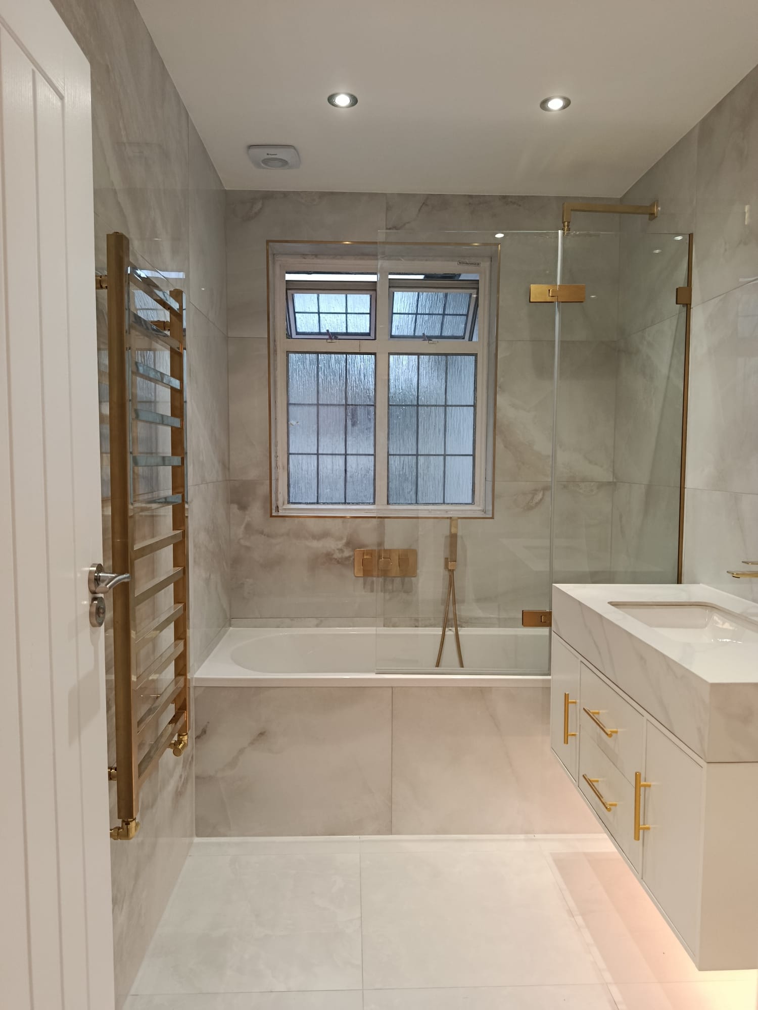 Small bathroom with calm neutral tiles, limited material changes and a clean finish palette for a more open look