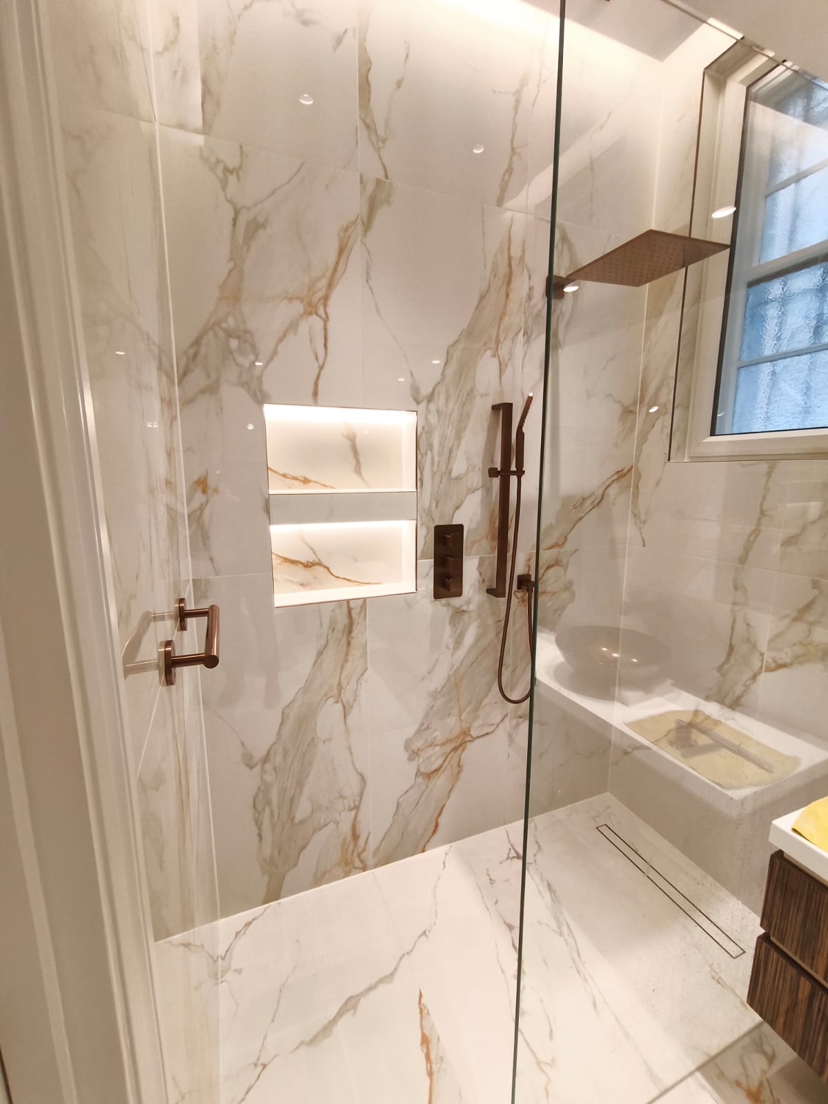 Built-in shower niche in a small bathroom with clean integrated storage