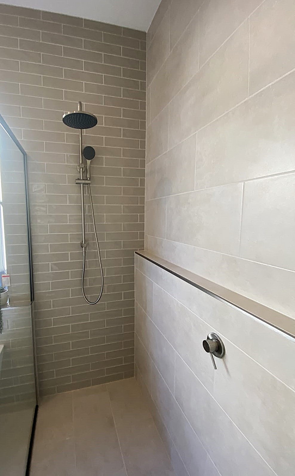 Different tile scales used across bathroom walls and floors