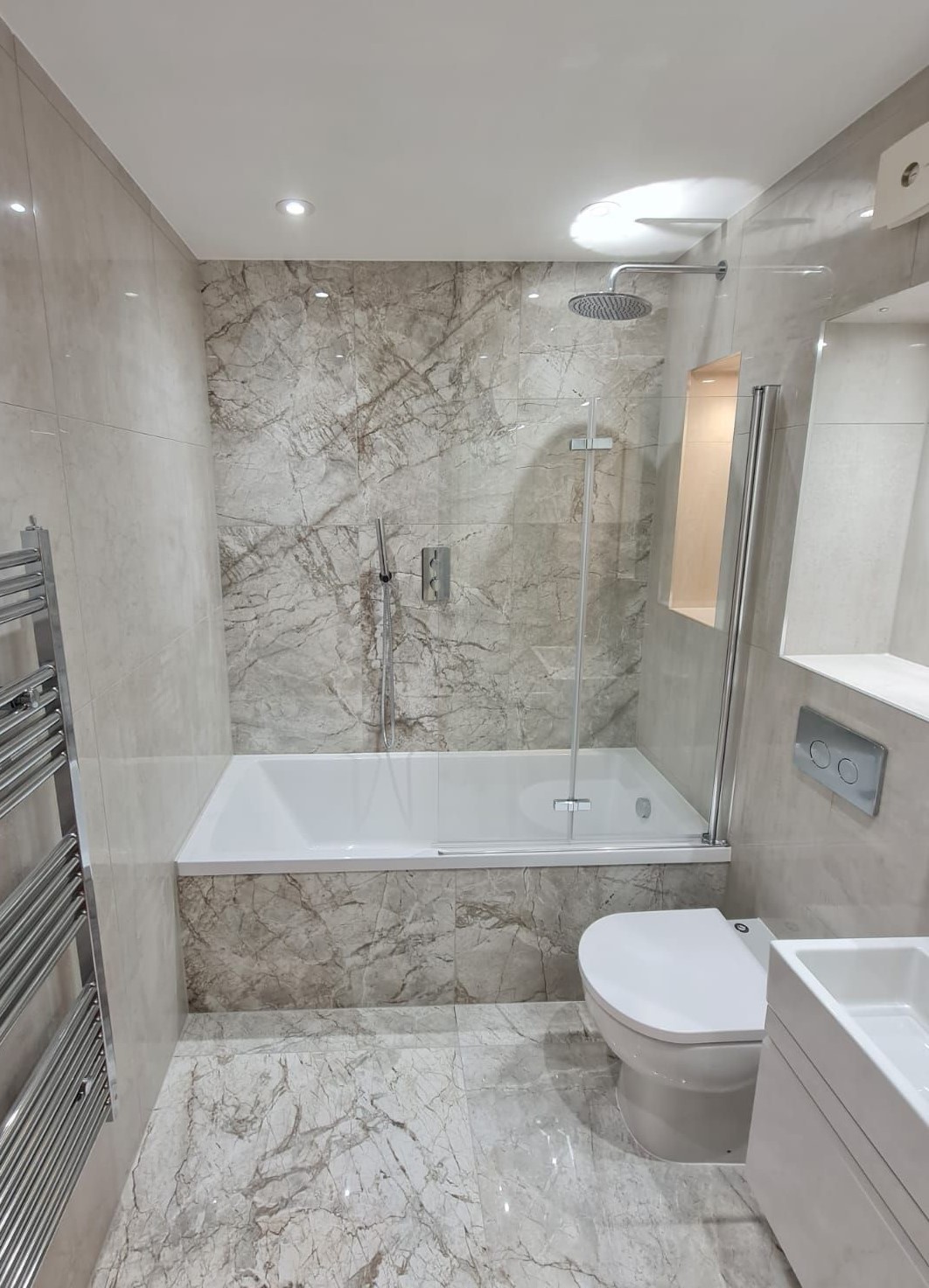 Bath with shower over it in a compact bathroom layout
