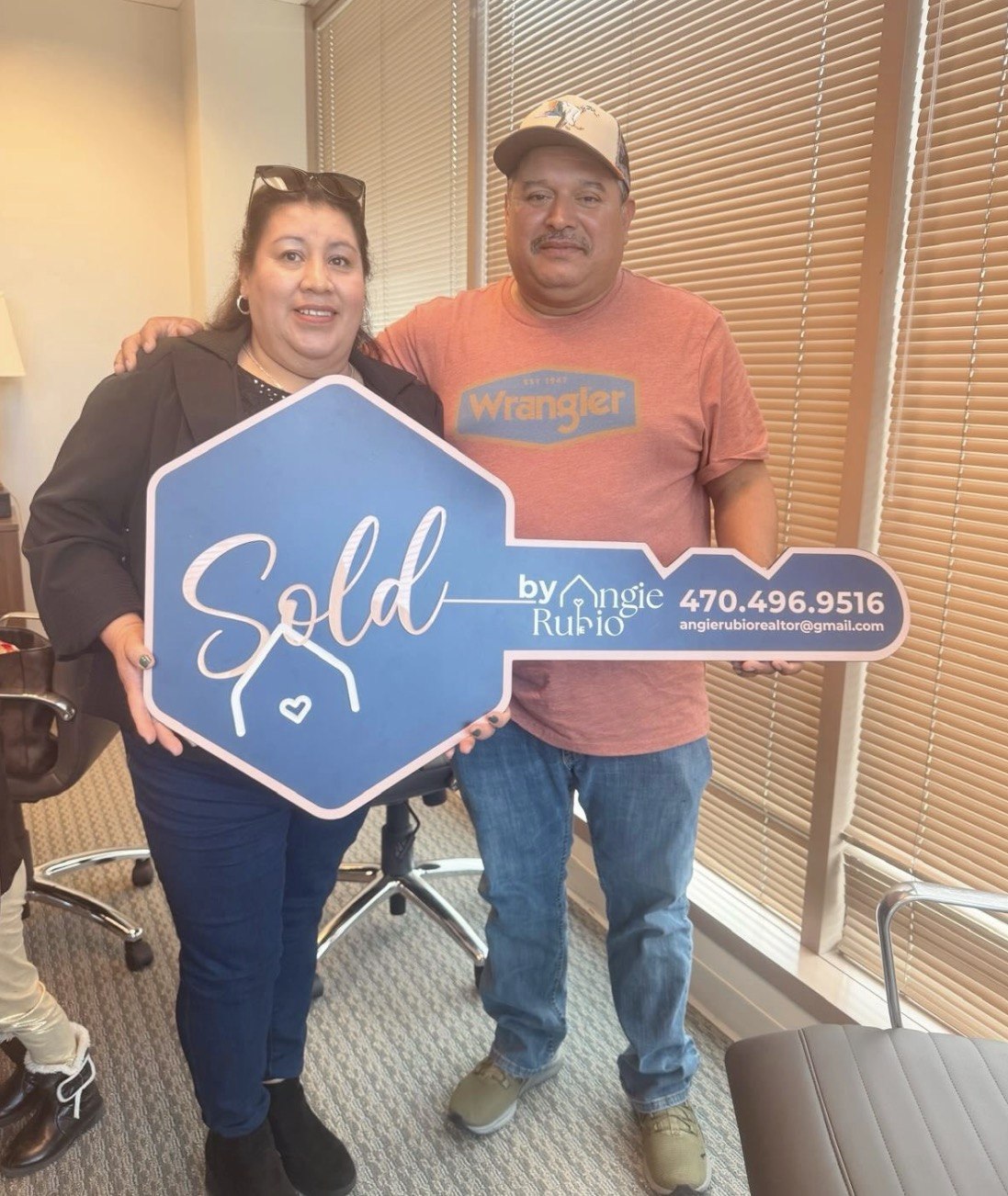 Clientes felices mostrando la llave de su nueva casa con Angie Rubio