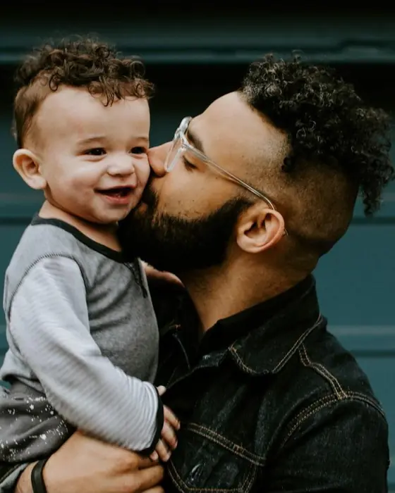 A father kisses his baby on the cheek