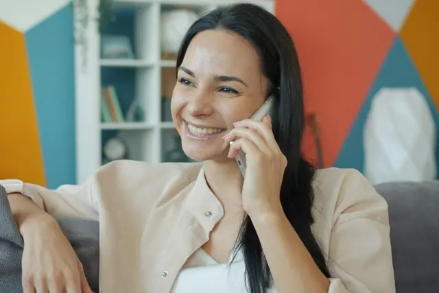 A woman smiles while talking on the phone