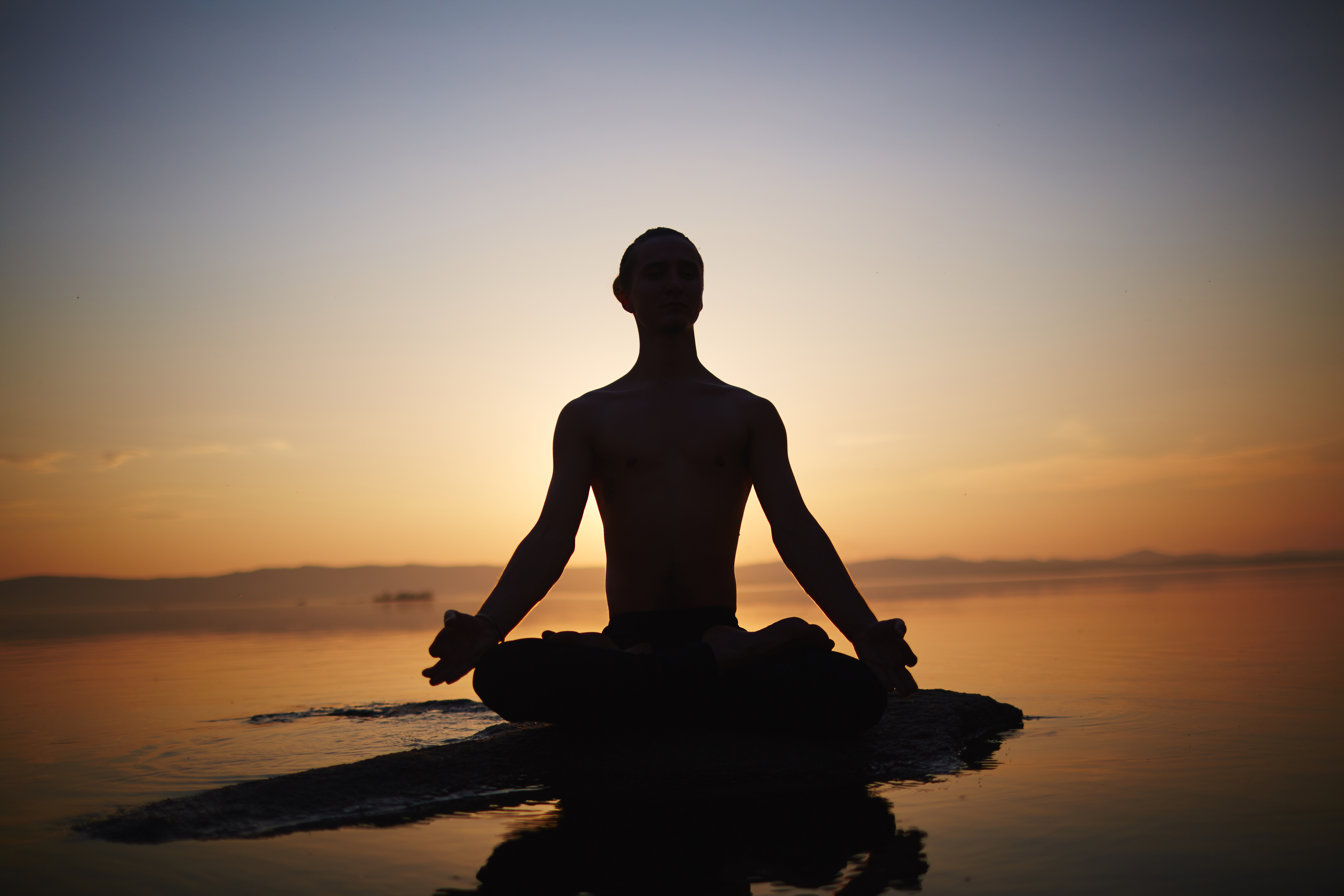 silhouette of woman standing on brown wooden dock during golden hour