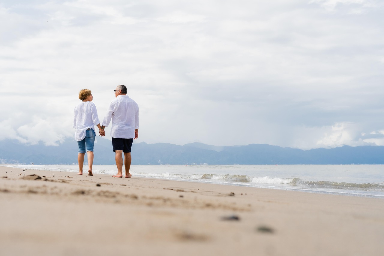 Couple holding hands walking on the beach