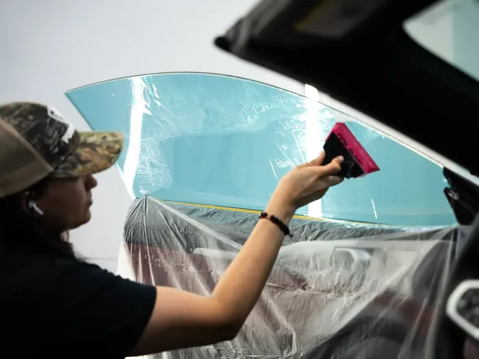 Peotter technician installing window tint on a side window
