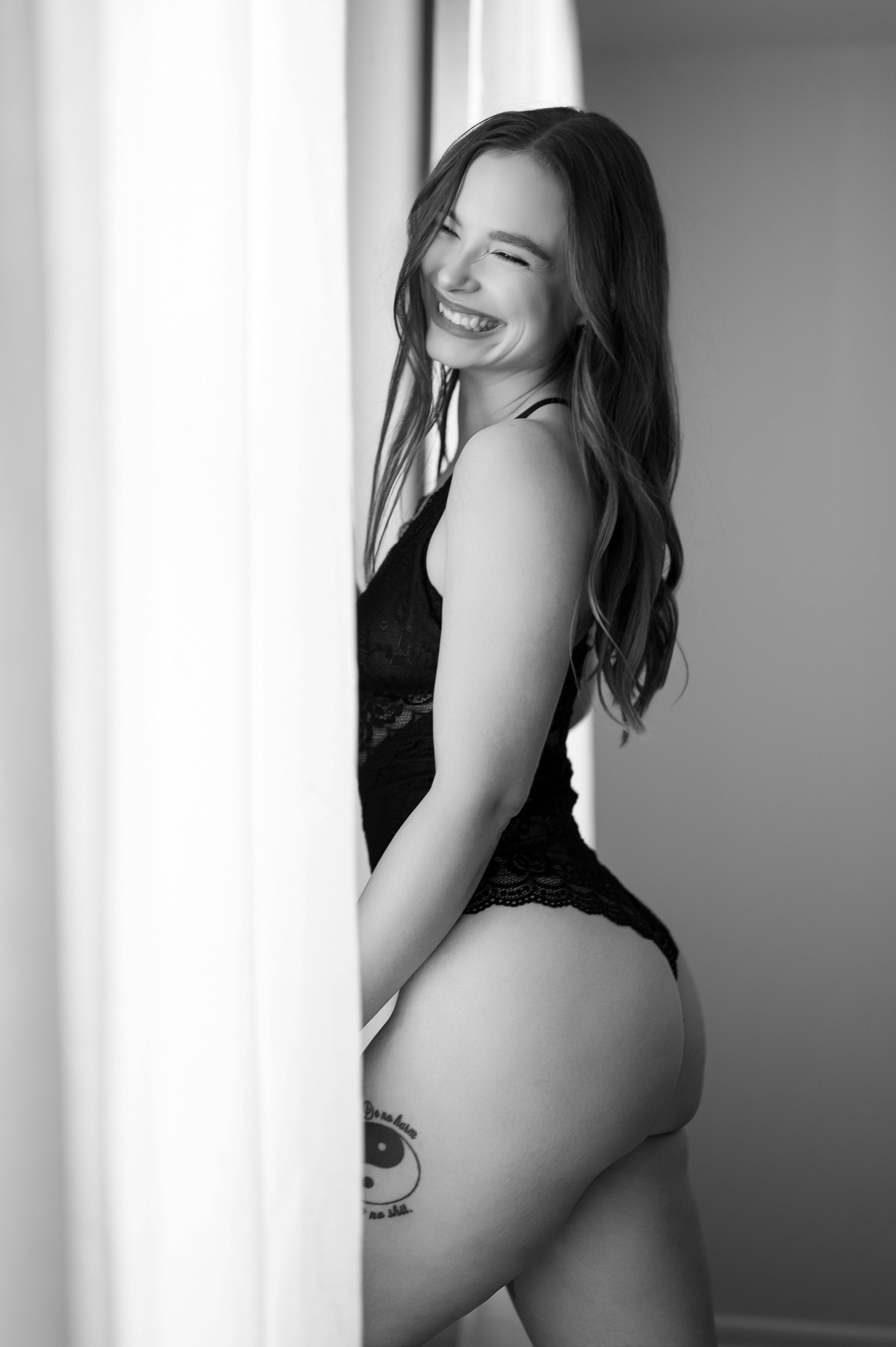 Romantic boudoir photography of a woman in pink floral lingerie and sheer robe, embracing beauty and feminine confidence.