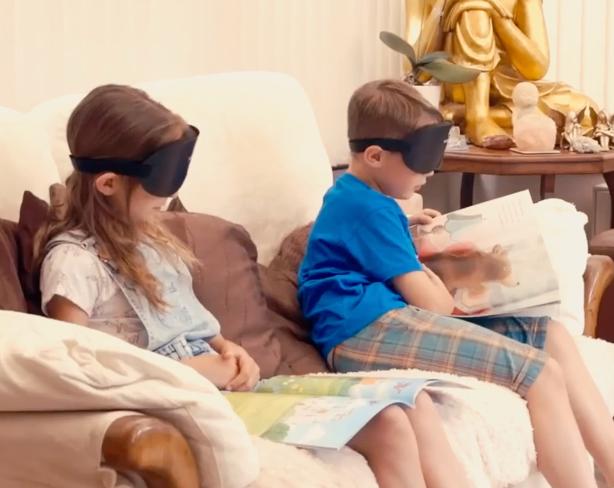 Two sighted children reading while wearing training masks
