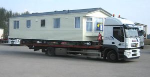 mobile home traveling on the trailer of a semi truck mobile home traveling on the trailer of a semi truck