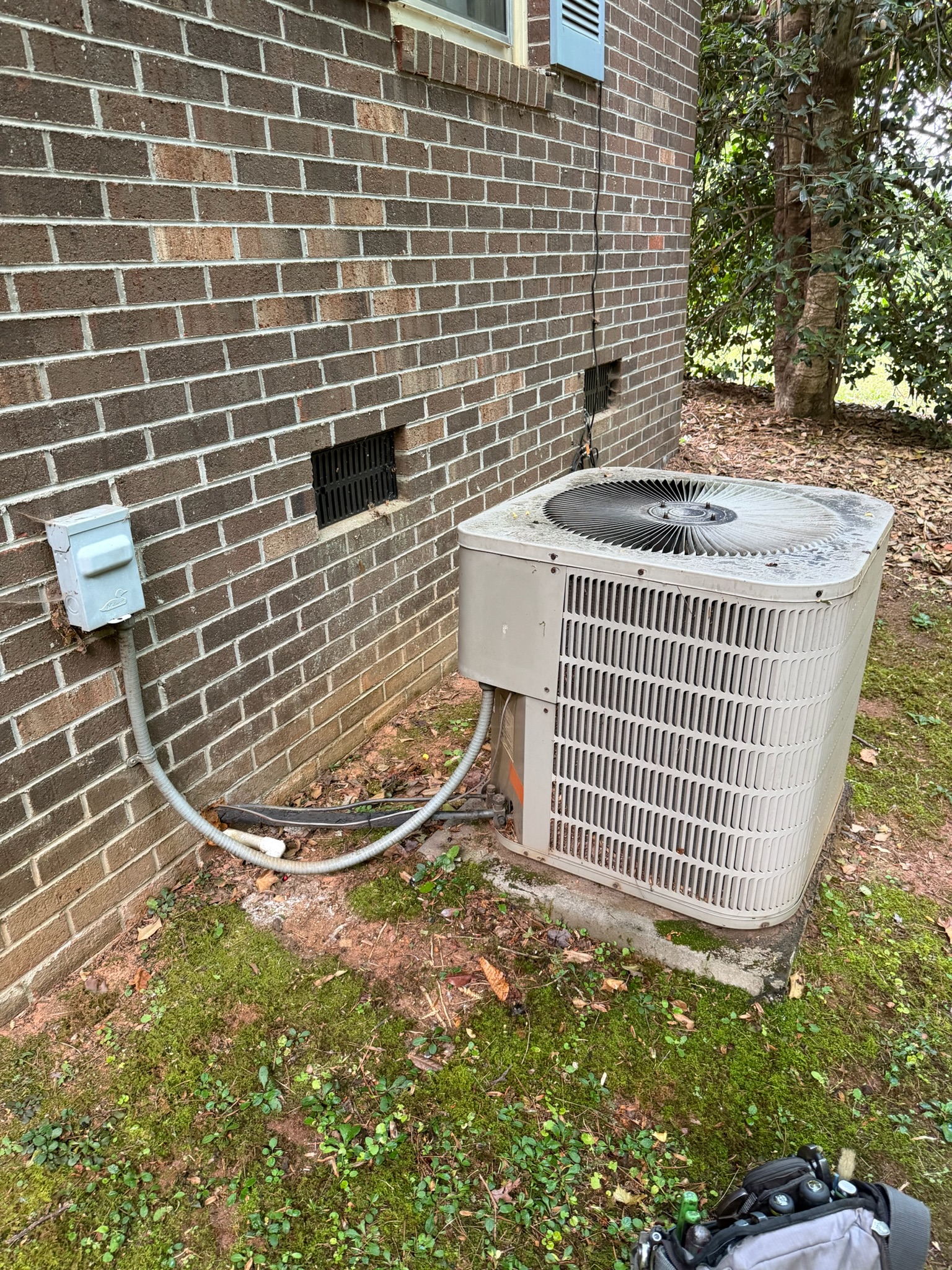 ECS tech inspecting AC condenser