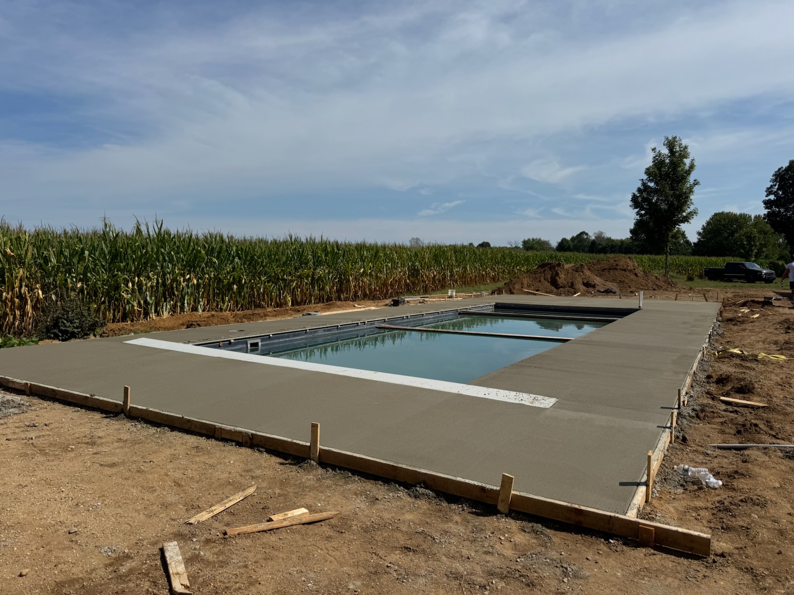 Freshly poured concrete pool deck surrounding an in-ground pool by Kelly’s Custom Concrete in Holland, MI.