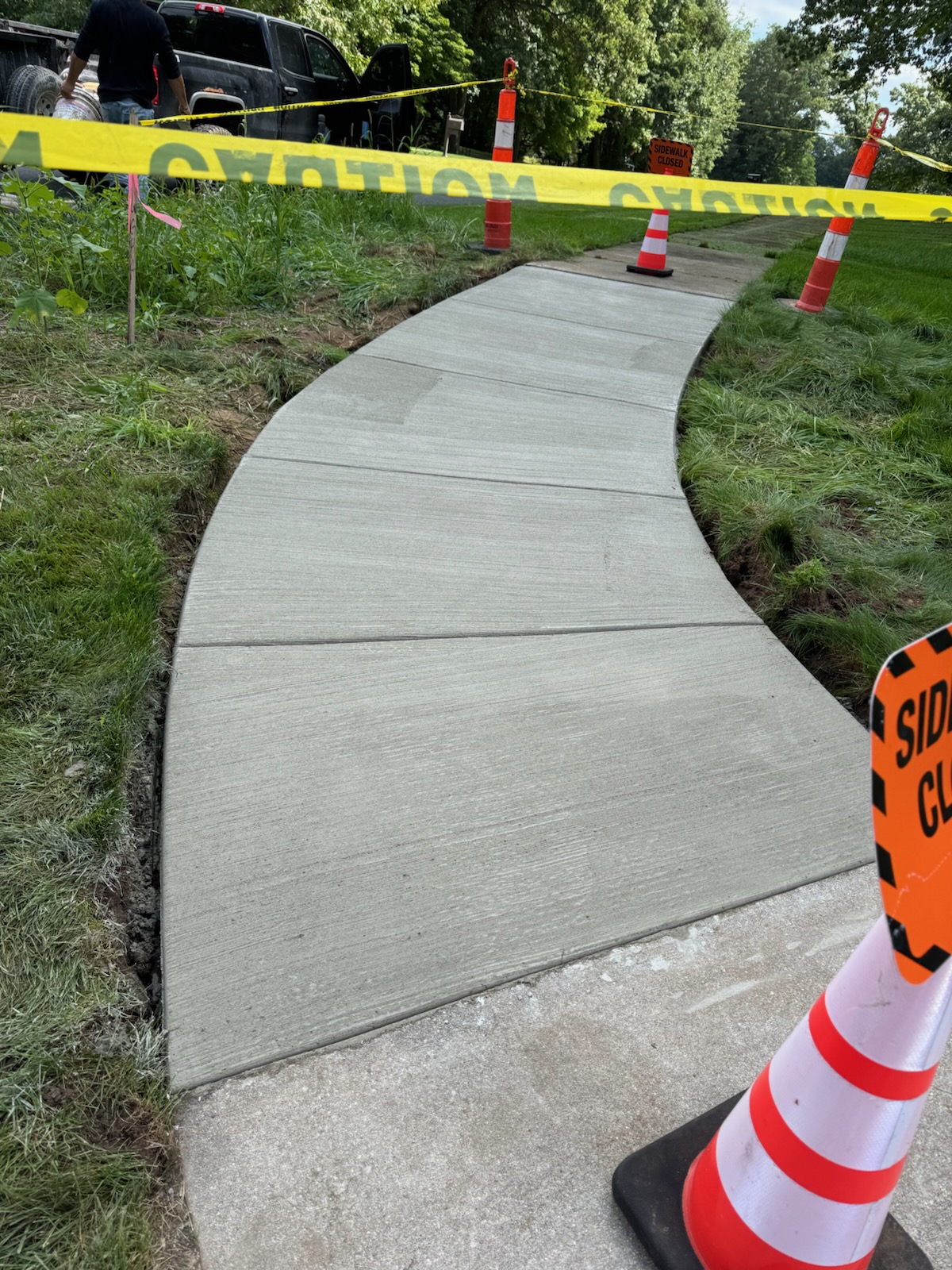 Newly poured curved concrete sidewalk with control joints