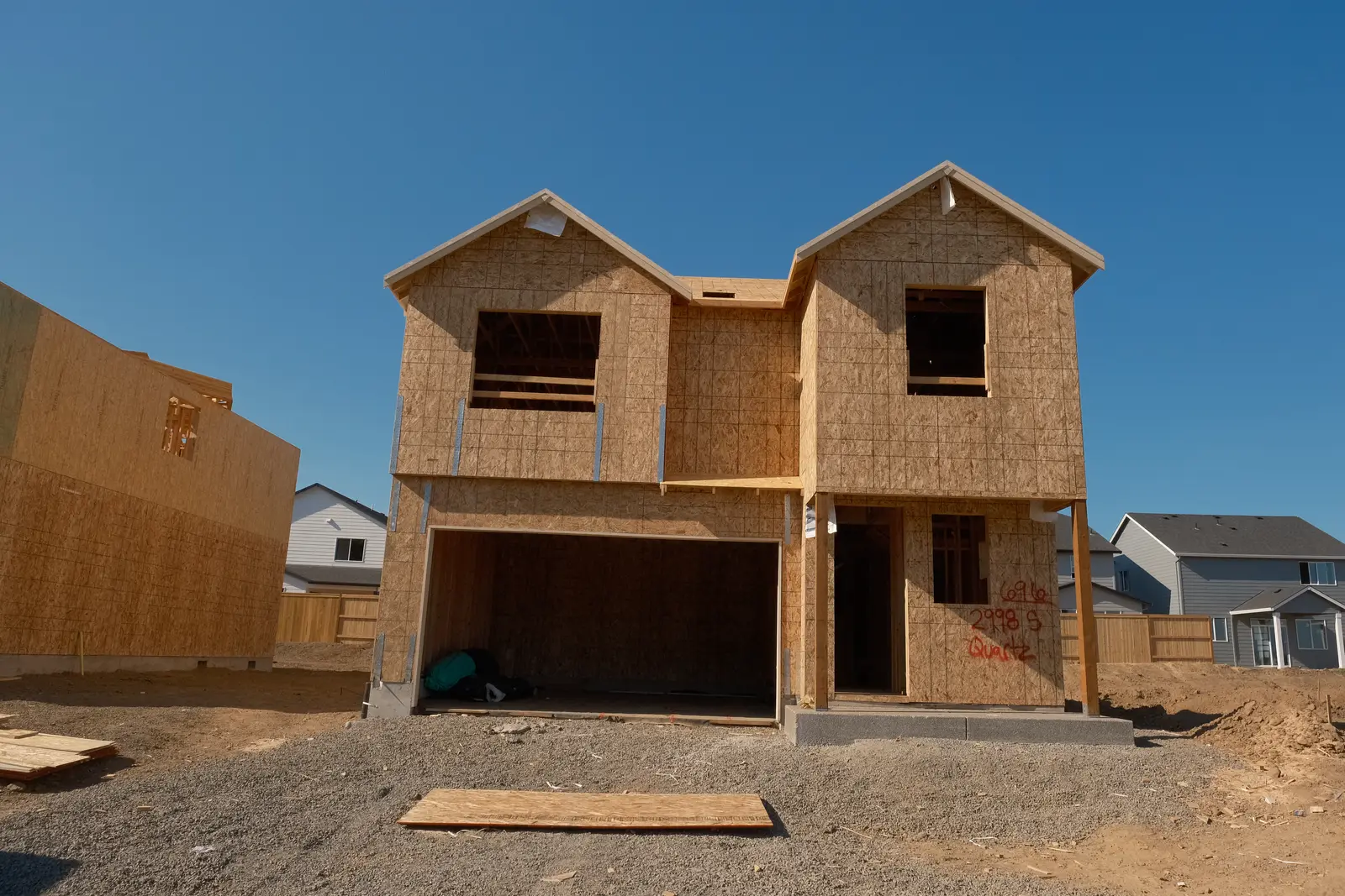 Wood-framed two-story home with exterior sheathing in progress at a Holt Homes project
