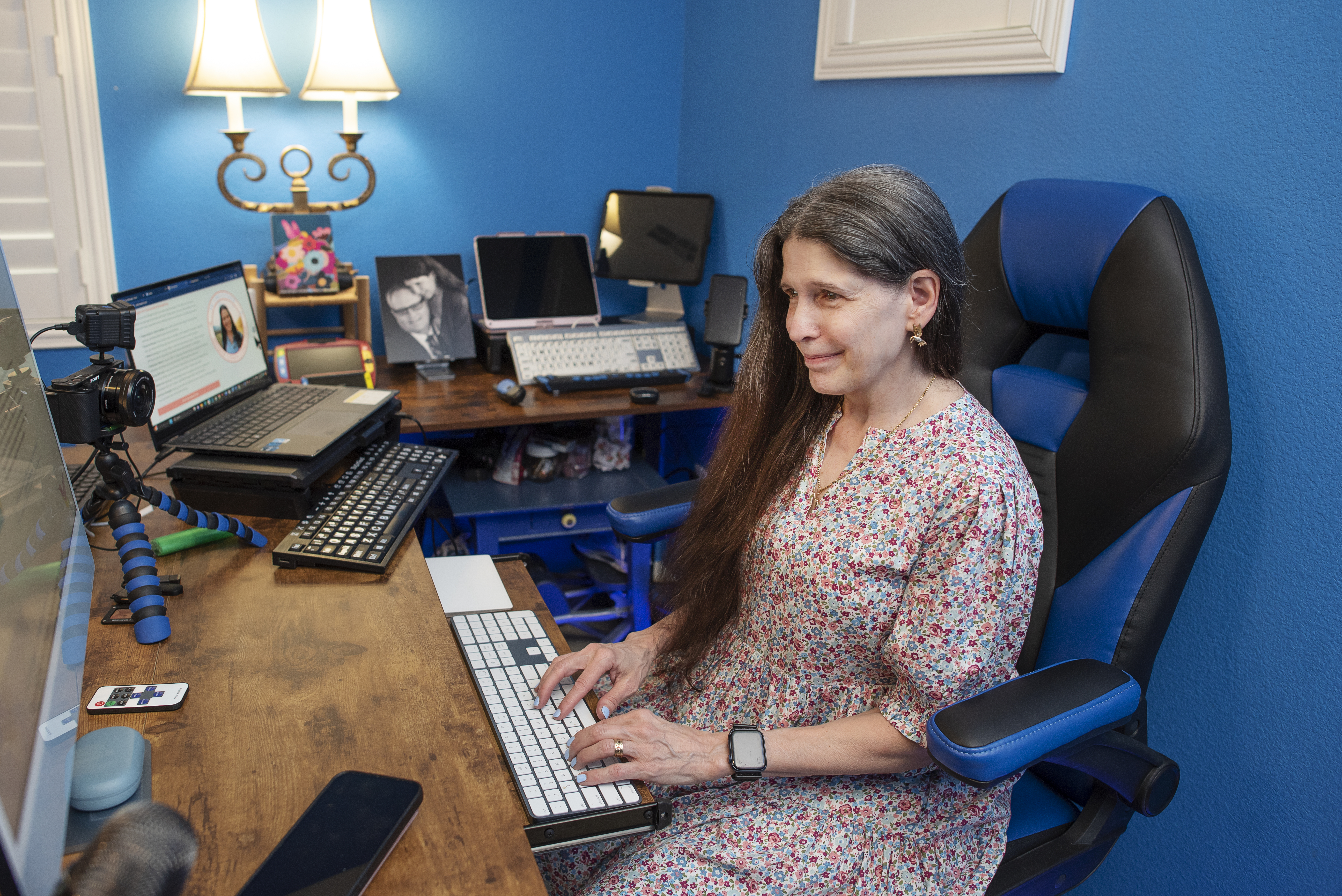 Victoria Essner, a blind professional and disability inclusion expert, sits at her desk in a home office using an accessible keyboard. A computer, camera, microphone, and other assistive technology are arranged around her workspace. Victoria Essner, a blind professional and disability inclusion expert, sits at her desk in a home office using an accessible keyboard. A computer, camera, microphone, and other assistive technology are arranged around her workspace.