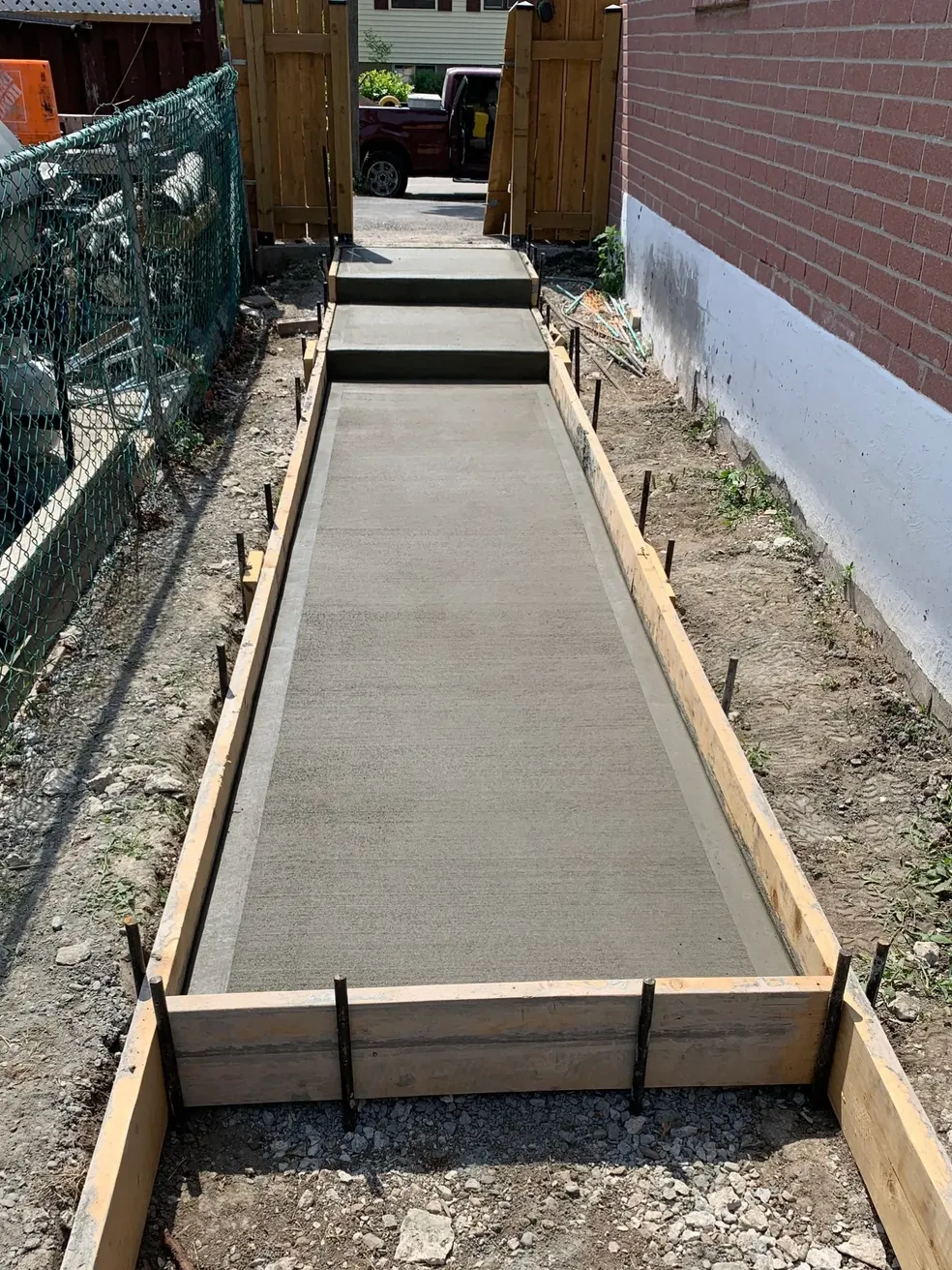 New concrete side walkway with steps formed between two houses in Richmond Hill