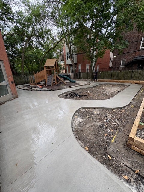 Curved concrete courtyard poured around garden beds in Markham