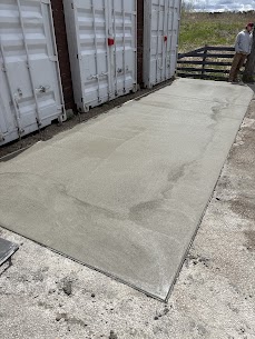 New concrete pad poured between storage containers in Oshawa