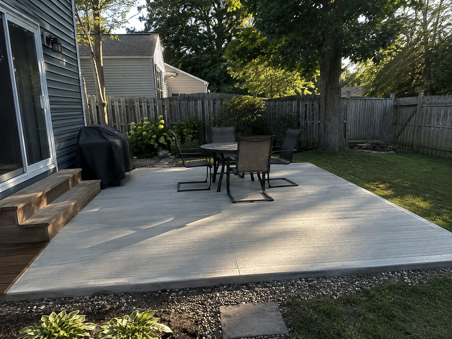Finished concrete backyard patio with furniture in Oakville