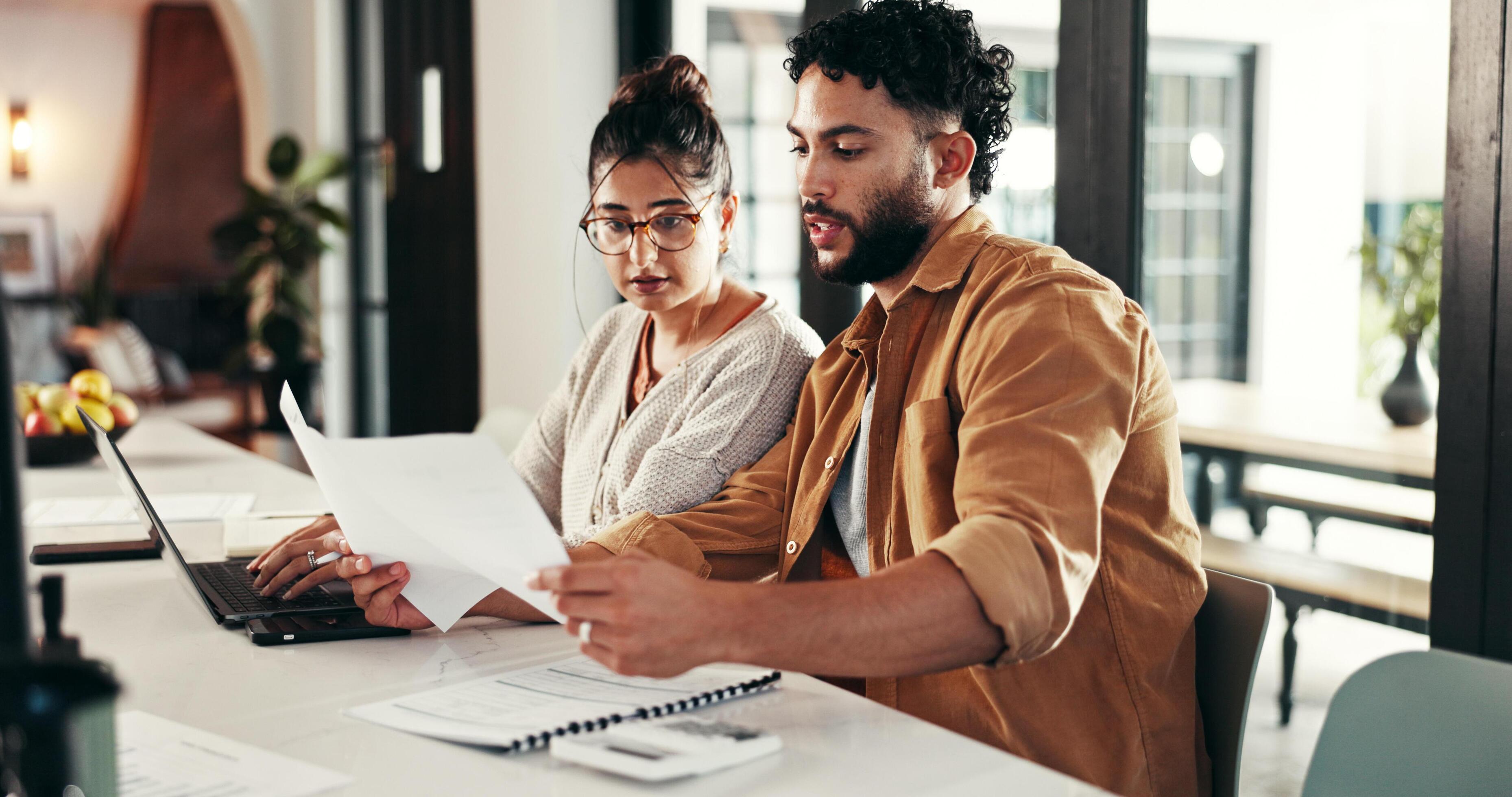 Couple reviewing paperwork or a house with documents