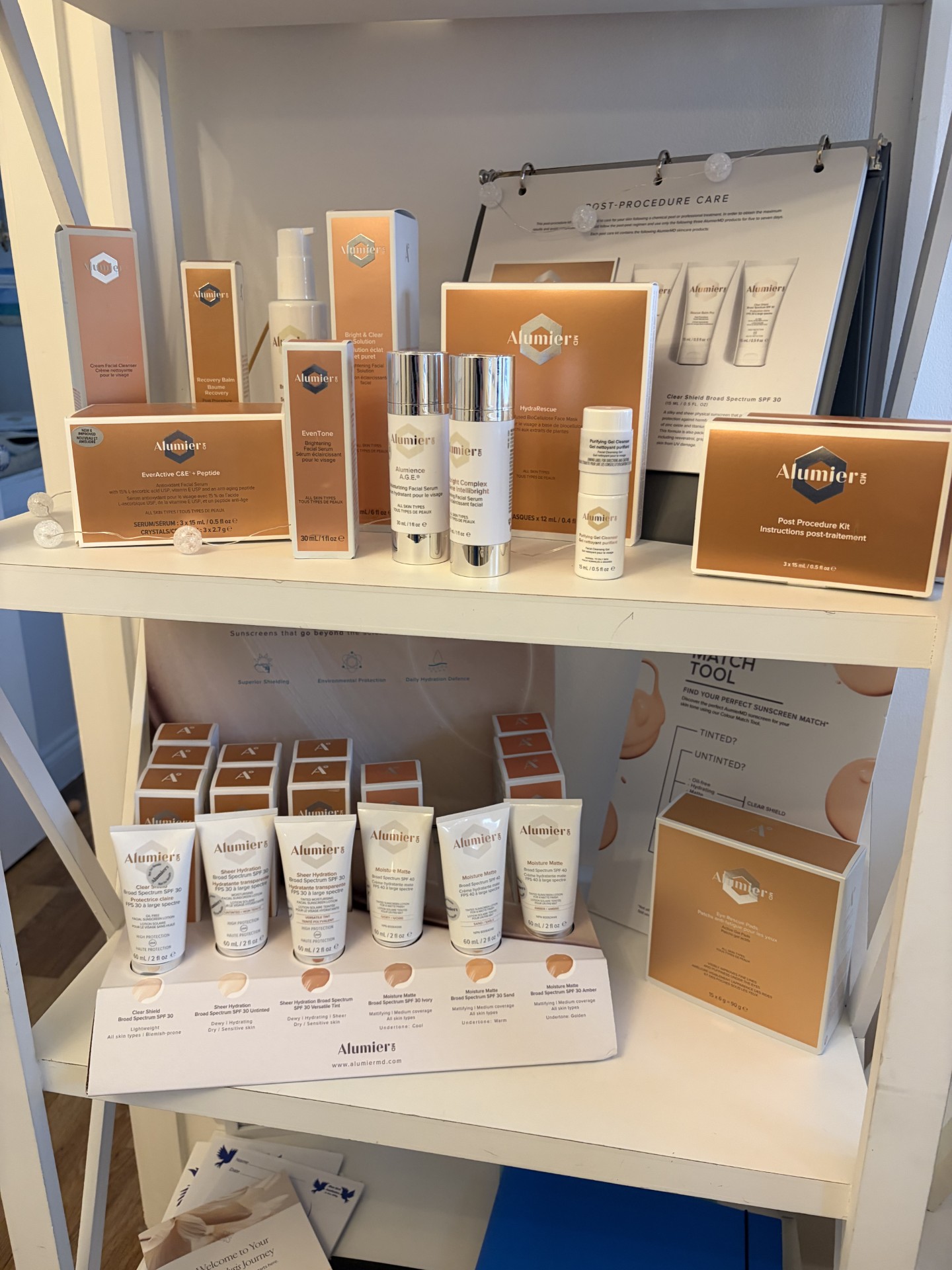 AlumierMD medical-grade skincare products on clinic shelf – boxed serums, cleansers, and treatments for acne, pigmentation, ageing, and sensitivity. Available in Worthing through consultation with Dr Amber Halliday at Blue Bird Aesthetics
