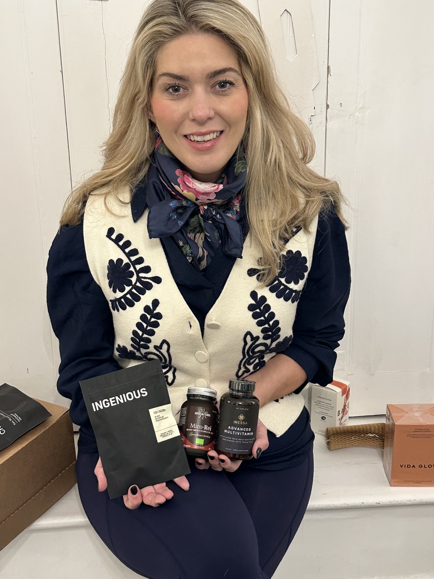 Dr Amber holding W-Wellness supplements – including Ingenious Collagen, Micro Rei, and Inessa Multivitamins – trusted nutritional products for vitality and wellbeing.