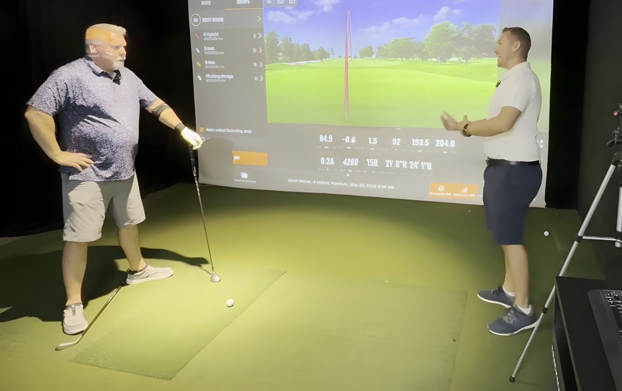 A Golf Guru coach going over TrackMan numbers with a golfer