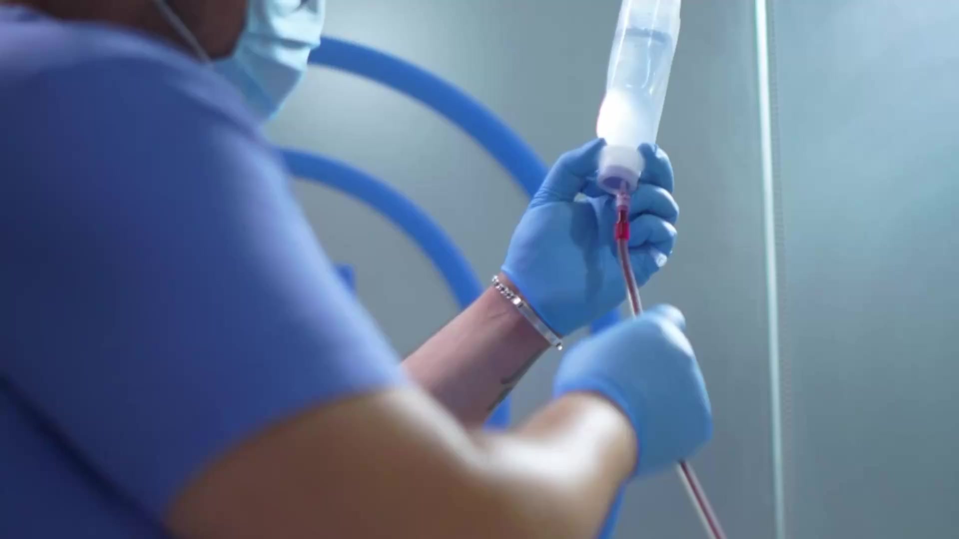 Gloved hands preparing treatment equipment