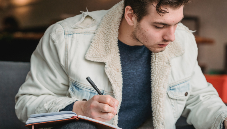 Man sitting quietly in reflection with open journal, searching for purpose and clarity Man sitting quietly in reflection with open journal, searching for purpose and clarity