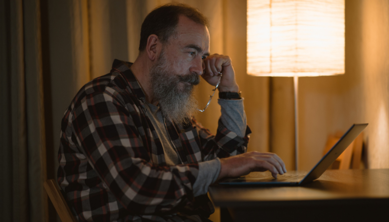 Tired man sitting at desk with head in hands, experiencing burnout from misaligned work Tired man sitting at desk with head in hands, experiencing burnout from misaligned work