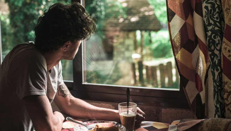 Man waking up early with intention, sitting in quiet morning reflection before the day begins