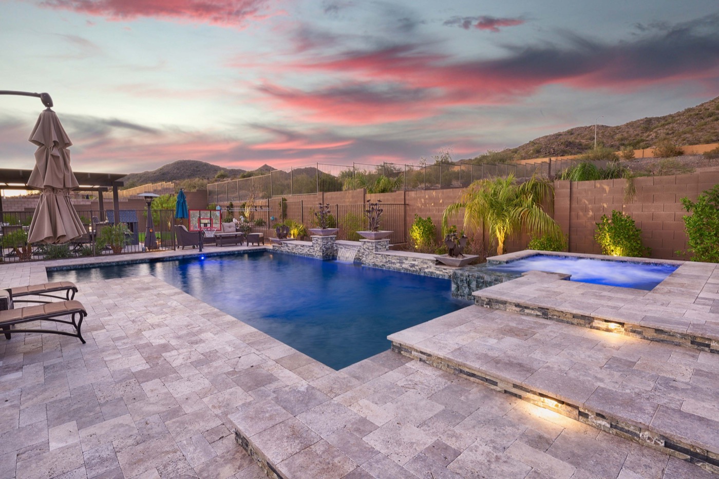 Custom pool with travertine deck and mountain sunset views — Phoenix Arizona