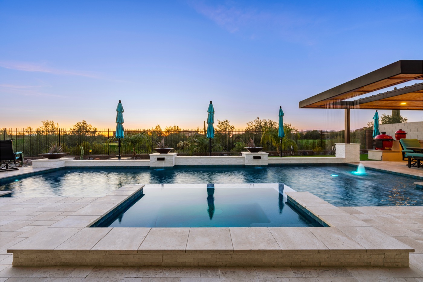 Geometric pool and spa with cascading water pavilion at twilight — Phoenix Arizona